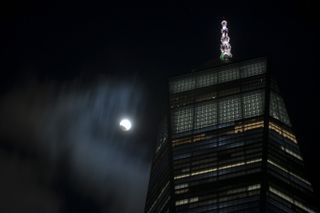 The moon is seen over the One World Trade Center during a total lunar eclipse, known as "Super Blood Wolf Moon" in Lower Manhattan, New York, United States on January 20, 2019