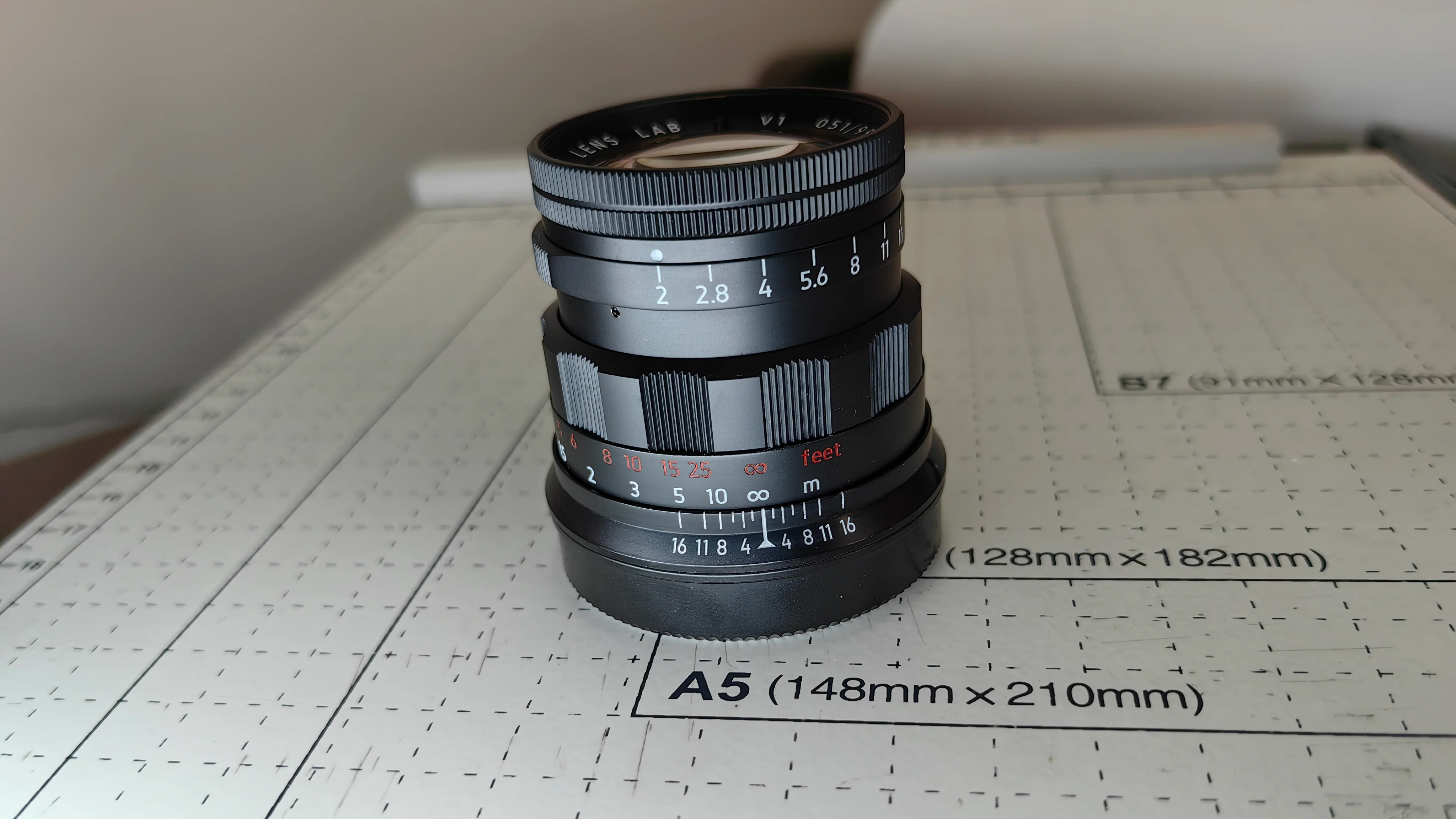 The Light Lens Lab 50mm f/2 in black, sitting on a table