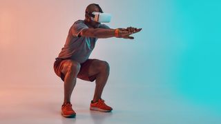 Young African man in sports clothing doing squat while wearing VR headset