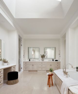 bathroom with marble bath surround and double vanity unit