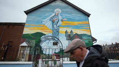  A man walks past a Catholic mural in Belfast 