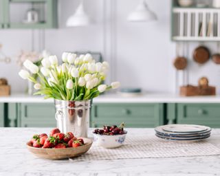 Bouquet of flowers and bowl of strawberries