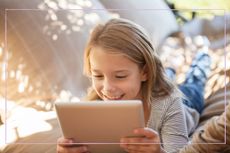 Girl smiling while she looks at her iPad