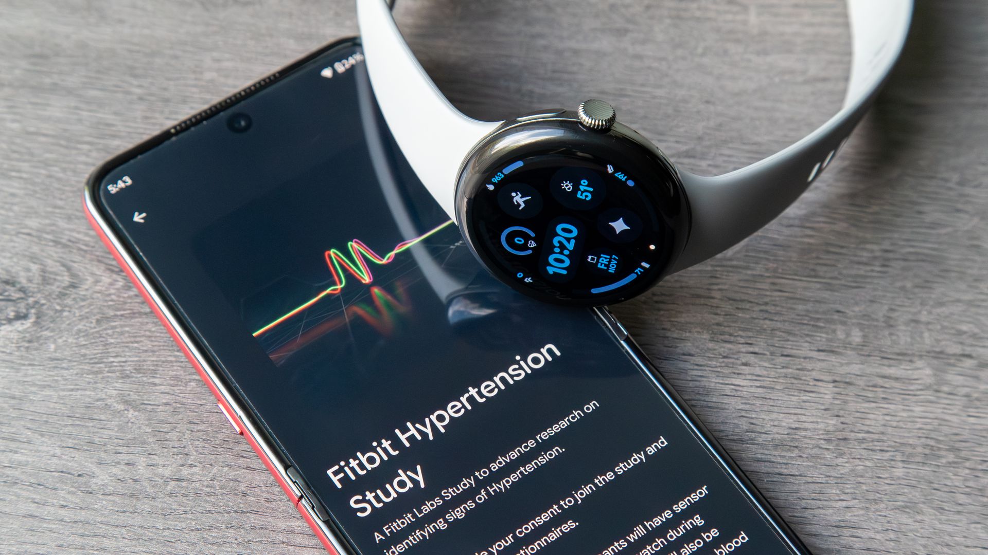 A photo of the Google Pixel Watch 3 sitting atop an Android phone showing a 