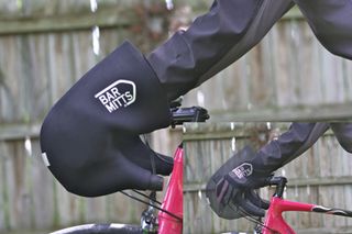 Image shows a rider using bar mitts to avoid cold hands while cycling.