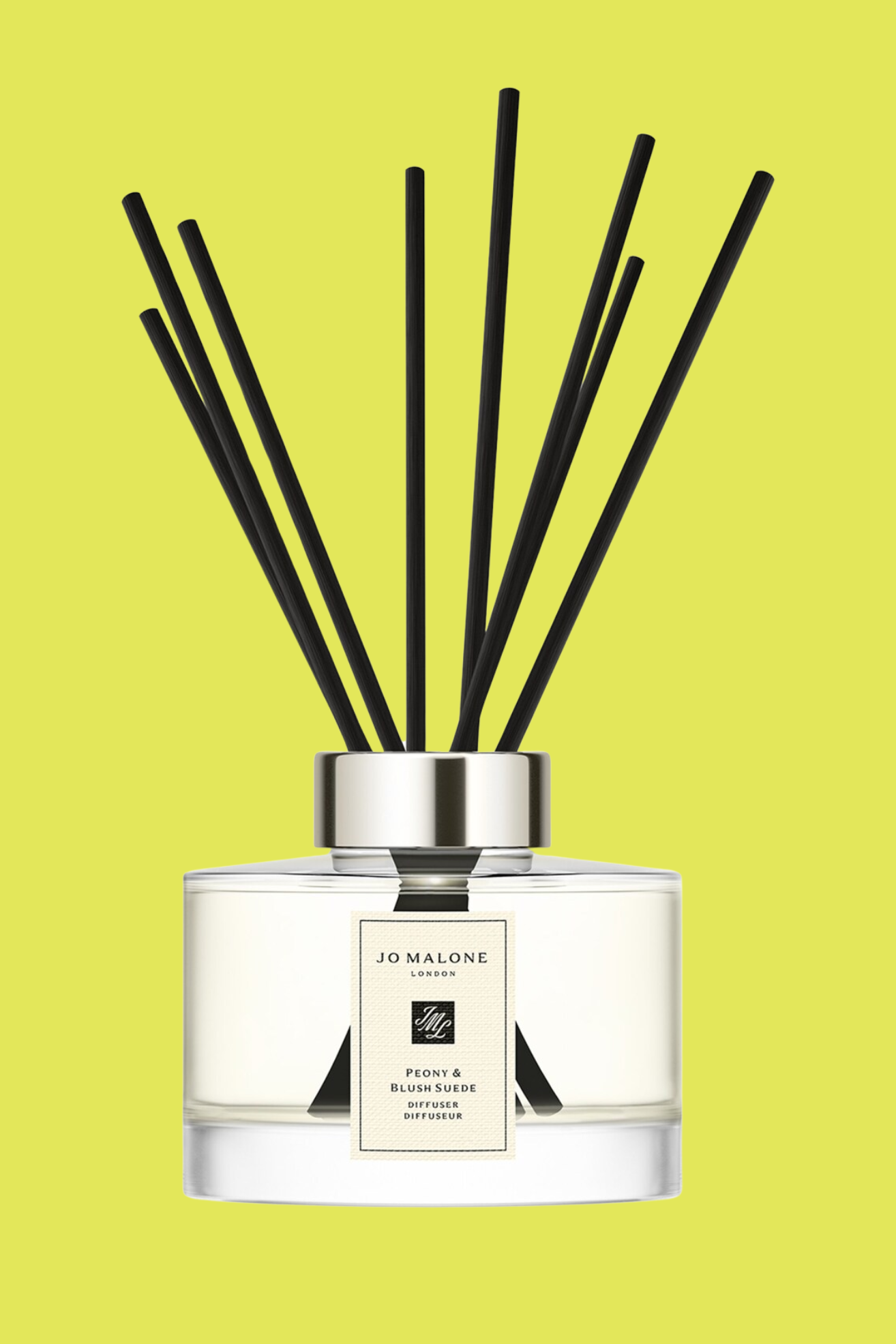A glass reed diffuser with black reeds