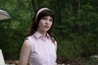 sophie thatcher as iris wearing a pink blouse and pink headband in the movie companion