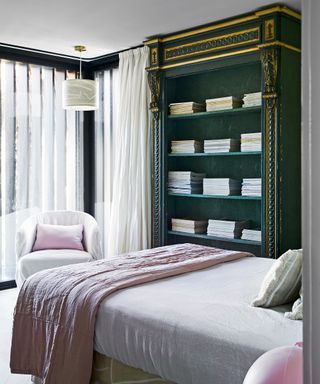 Bedroom with green painted antique bookcase