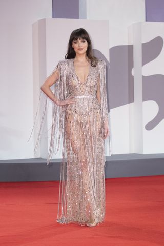 Dakota Johnson wears a sheer gown with crystal fringe