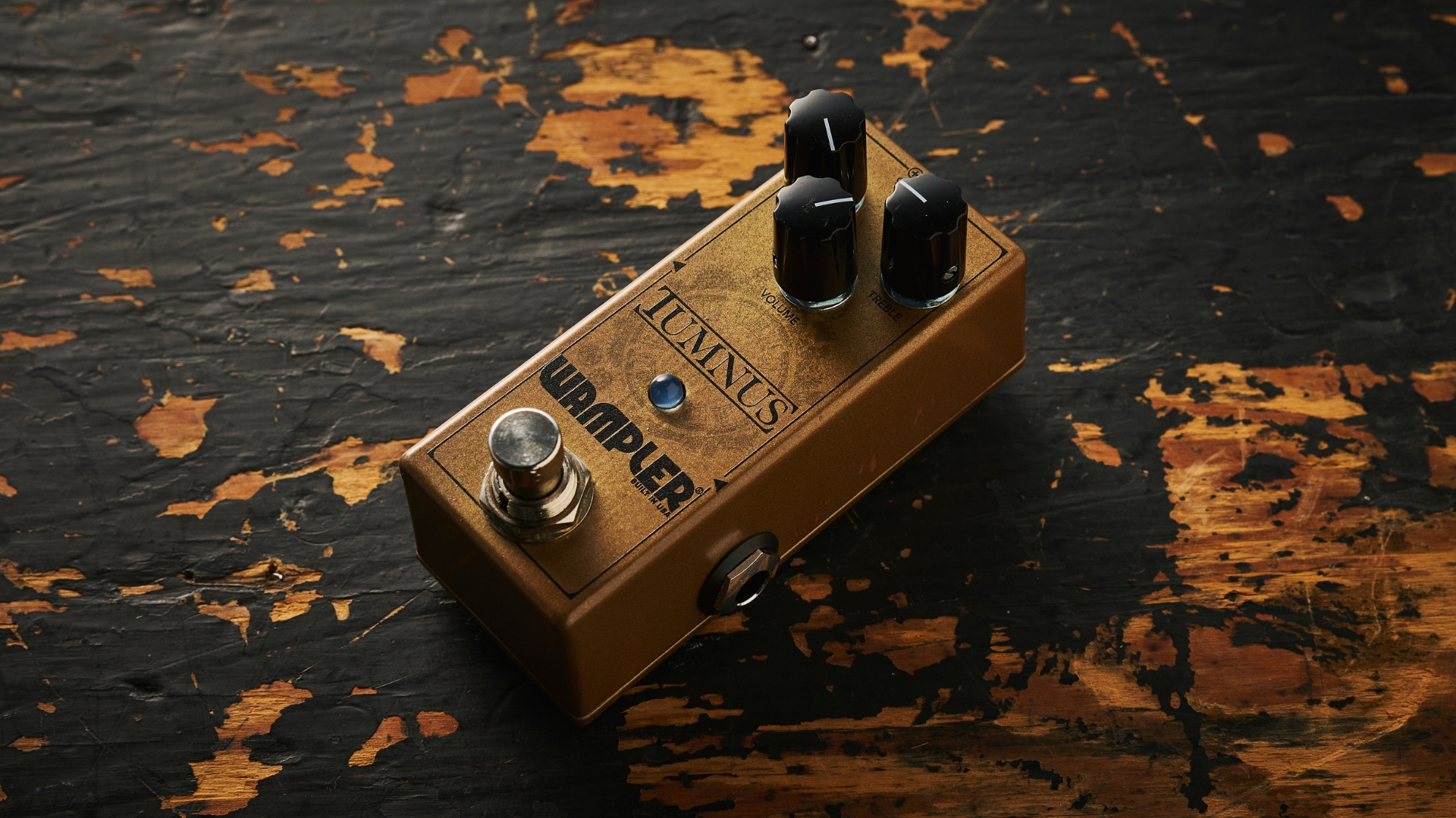 A Wampler Tumnus overdrive pedal on a worn wooden floor