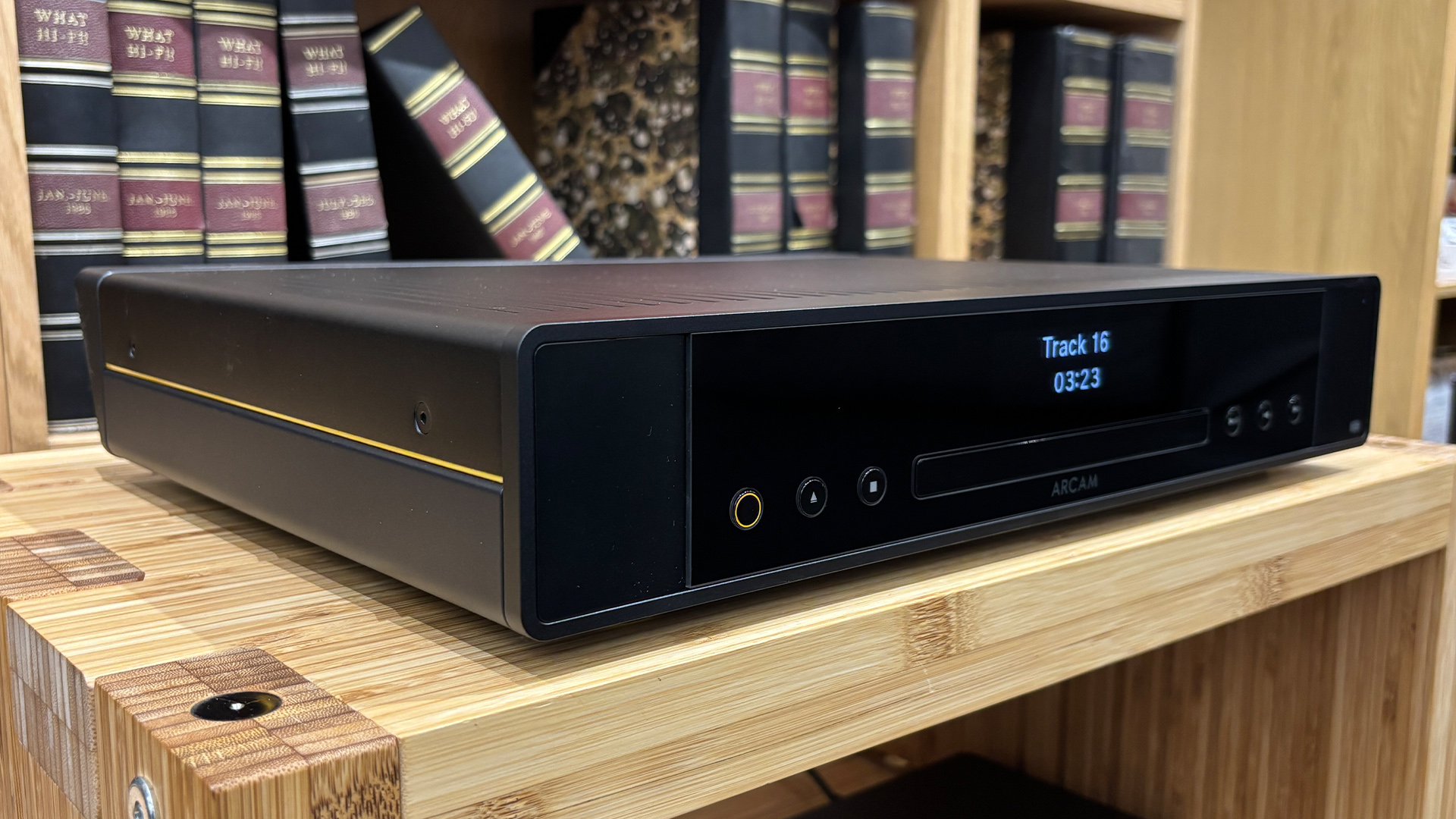 Arcam CD25 CD player on wooden hi-fi rack in front of bookcase