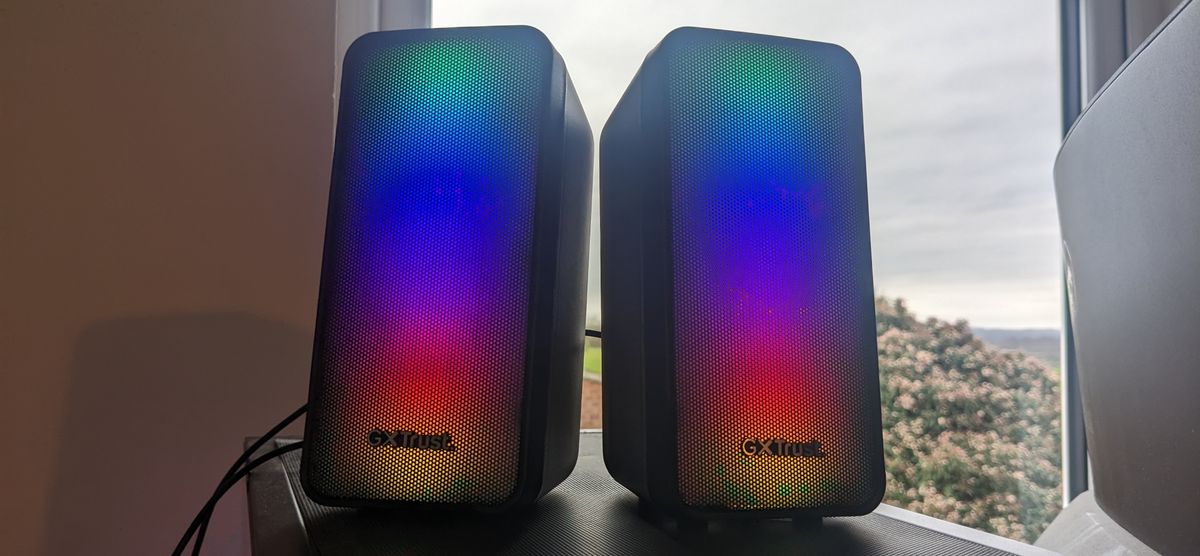 The Trust GXT 611 Wezz RGB speakers pictured on a wooden desk.