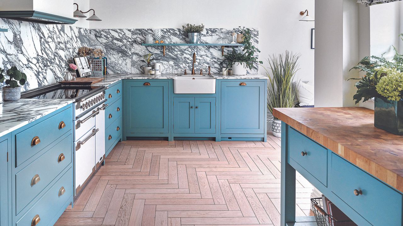 Mediterranean blue kitchen with shaker cupboards, belfast sink and herringbone flooring.