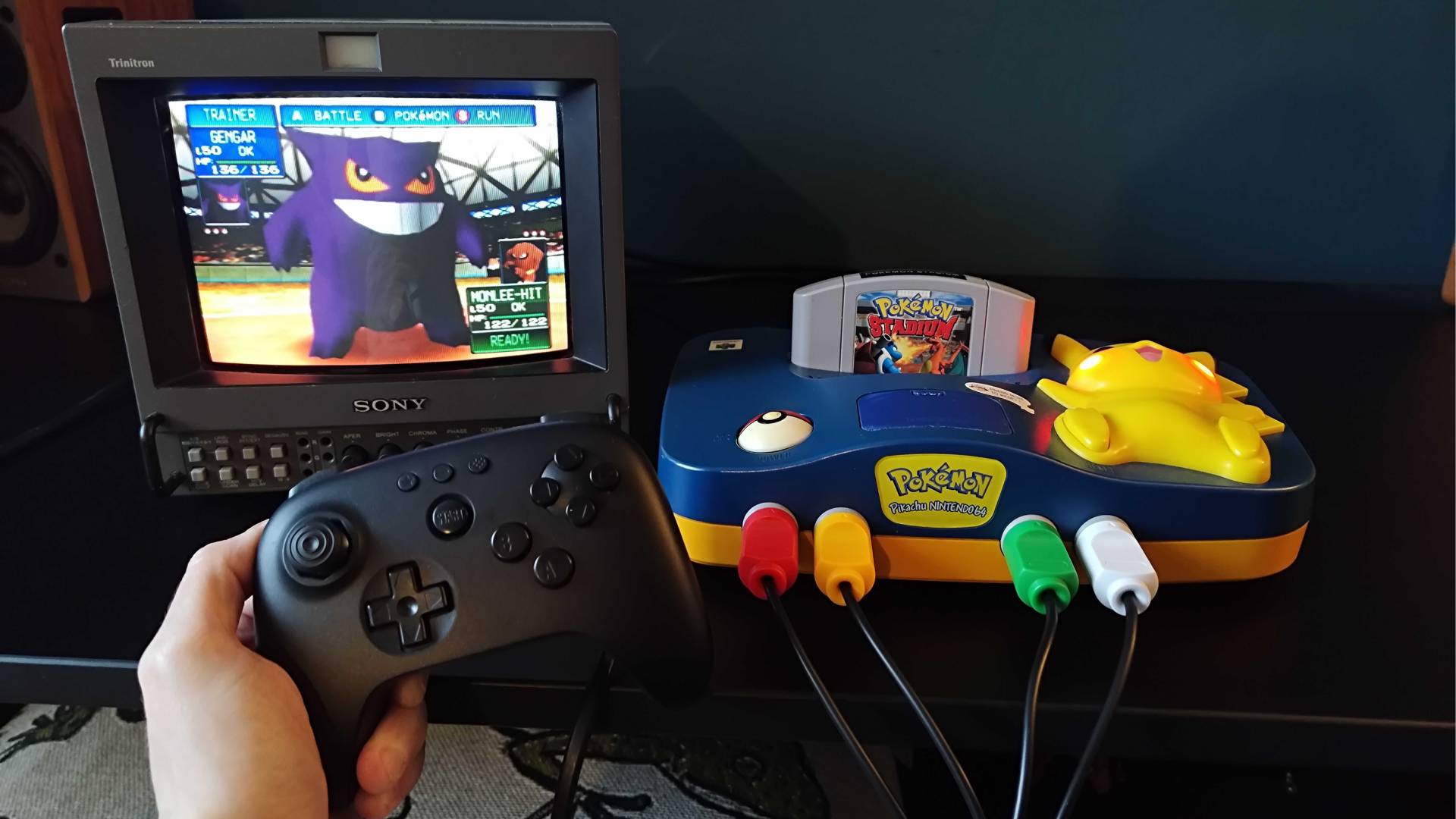 Pikachu N64 connected to Sony PVM CRT with hand holding 8Bitdo N64 controller and Gengar on screen.