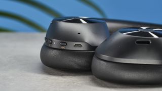 a pair of black bluetooth headphones made by OneOdio Focus A5 is photographed against a blue background