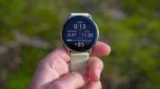 a close-up picture of our reviewer holding the Garmin Venu 4 smartwatch displaying real-time workout stats