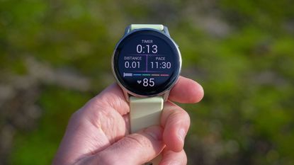 a close-up picture of our reviewer holding the Garmin Venu 4 smartwatch displaying real-time workout stats