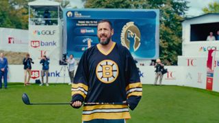 Adam Sandler as Happy Gilmore in Bruins uniform holding driver in Happy Gilmore 2