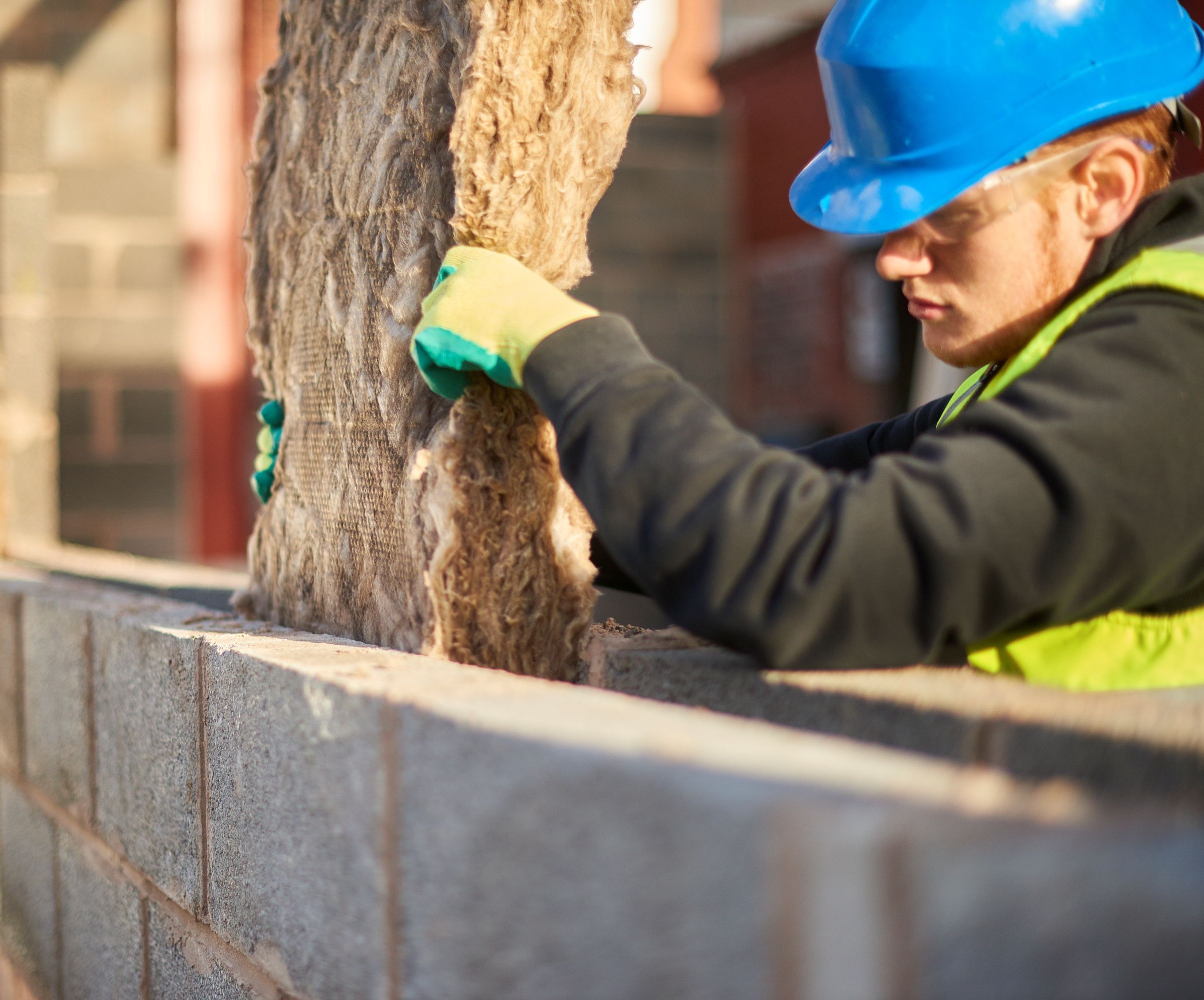 A man putting insulation into a void in a cavity wall