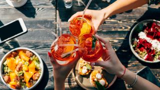 People toasting non-alcohol aperol spritz, one of the wellness trends for 2022