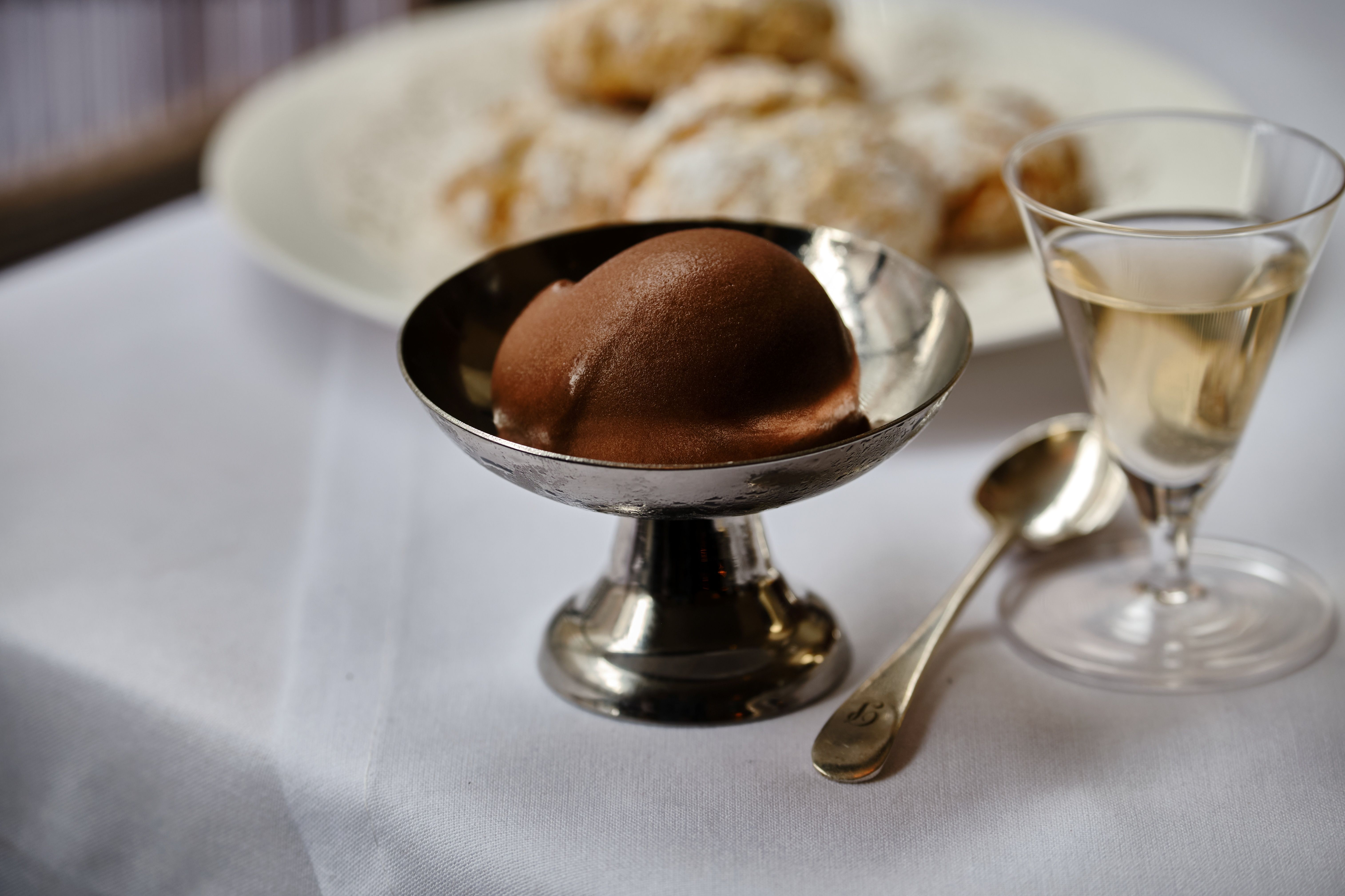 A series of interior shots of a restaurant lit with candles and decorated with traditional serveware, framed wooden paintings, and wooden detailing.