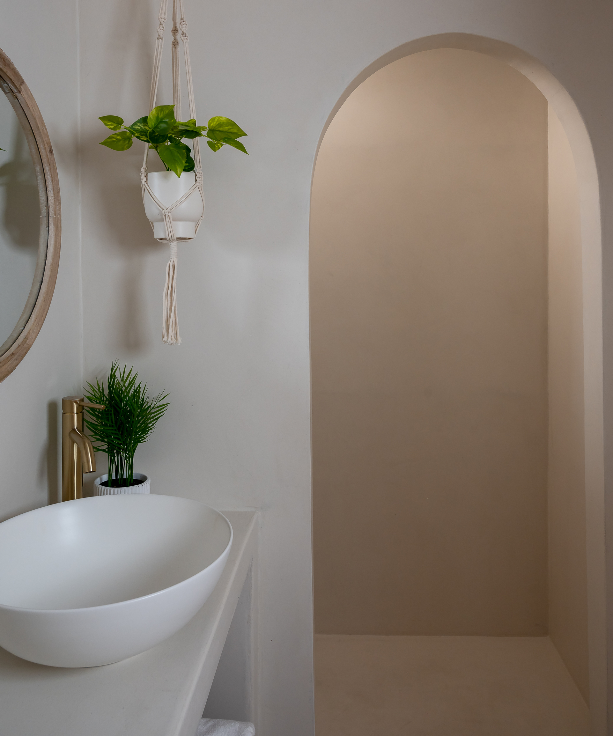 bathroom with archway into shower area, all coated in microcement