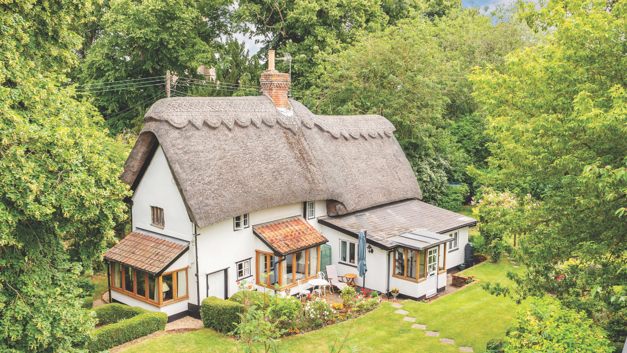 A thatched cottage set in mature gardens.