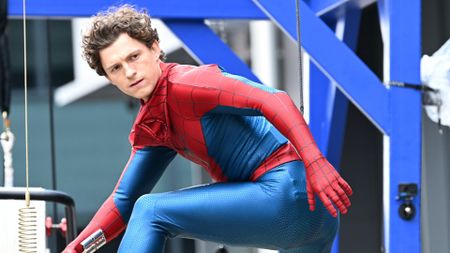 Tom Holland's unmasked superhero posing and looking over his left shoulder in Spider-Man: Brand New Day