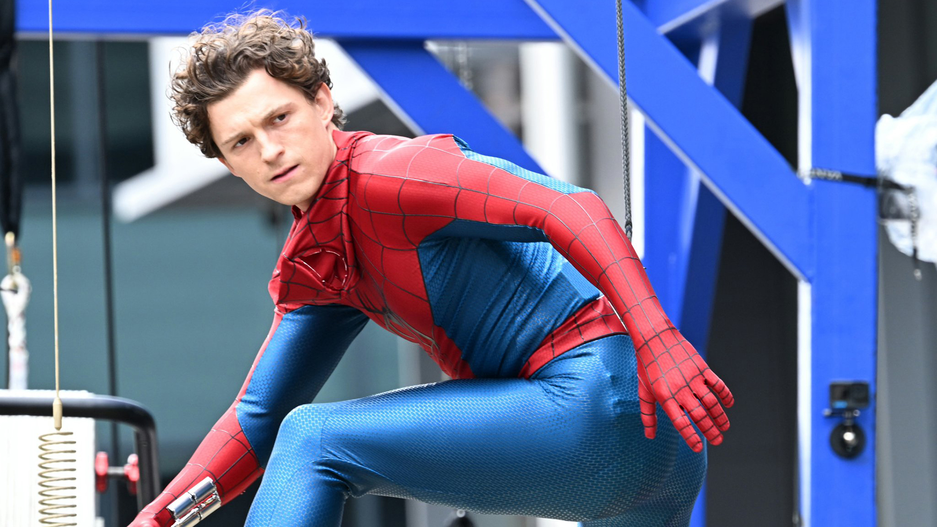 Tom Holland&#039;s unmasked superhero posing and looking over his left shoulder in Spider-Man: Brand New Day
