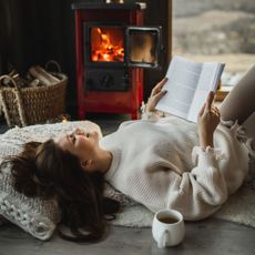 Winter slump: A woman reding her book by the fire