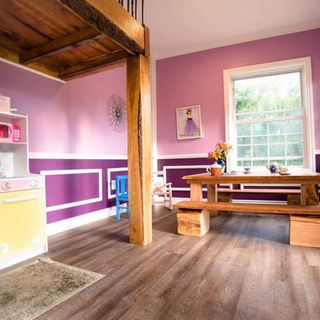 room with wooden flooring and purple wall