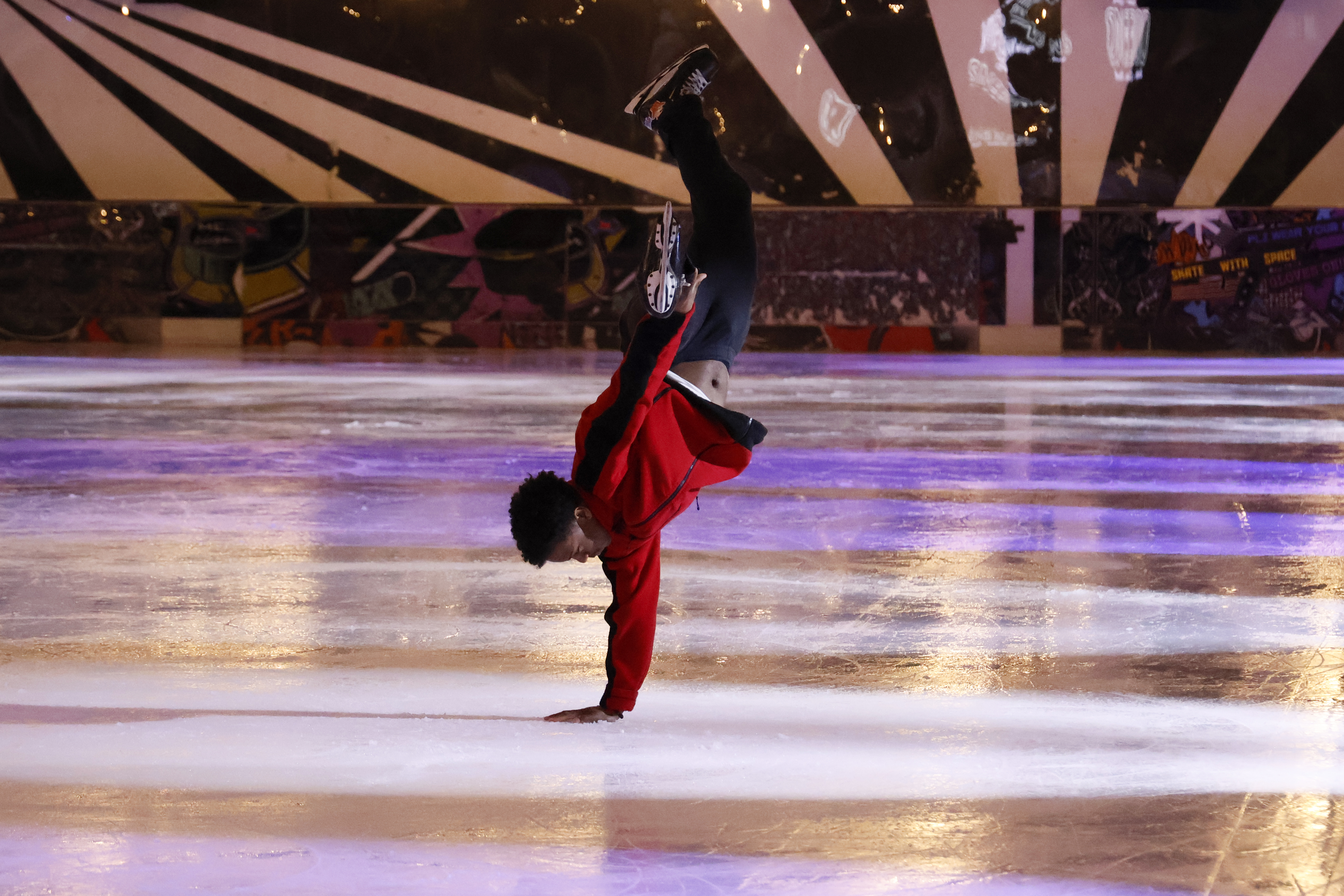 An ice skater performing at an ice rink