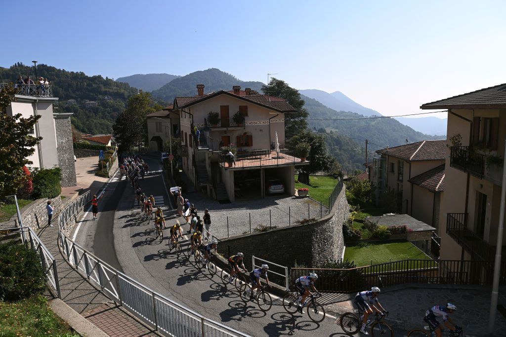 Peloton passing through a village during the 117th Il Lombardia 2023