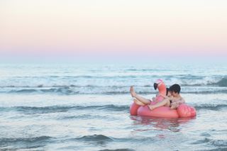 Sex dreams meaning: A couple kiss on a floating flamingo