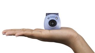 Blue Fujifilm Instax Pal in the palm of a hand on a white background