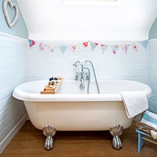 Neutral roll top bath tub with silver feet