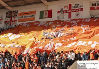Blackpool fans unfurl a banner in a game against Bolton Wanderers in February 2024.