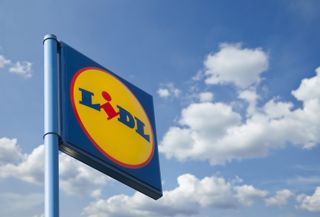A sign showing the Lidl logo in front of a cloudy sky