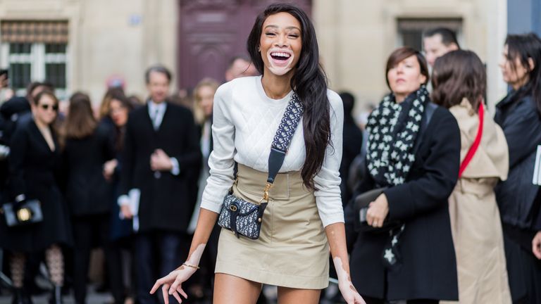 paris, france march 03 model winnie harlow wearing white knit, mini skirt, boots, dior bag outside dior on march 3, 2017 in paris, france photo by christian vieriggetty images