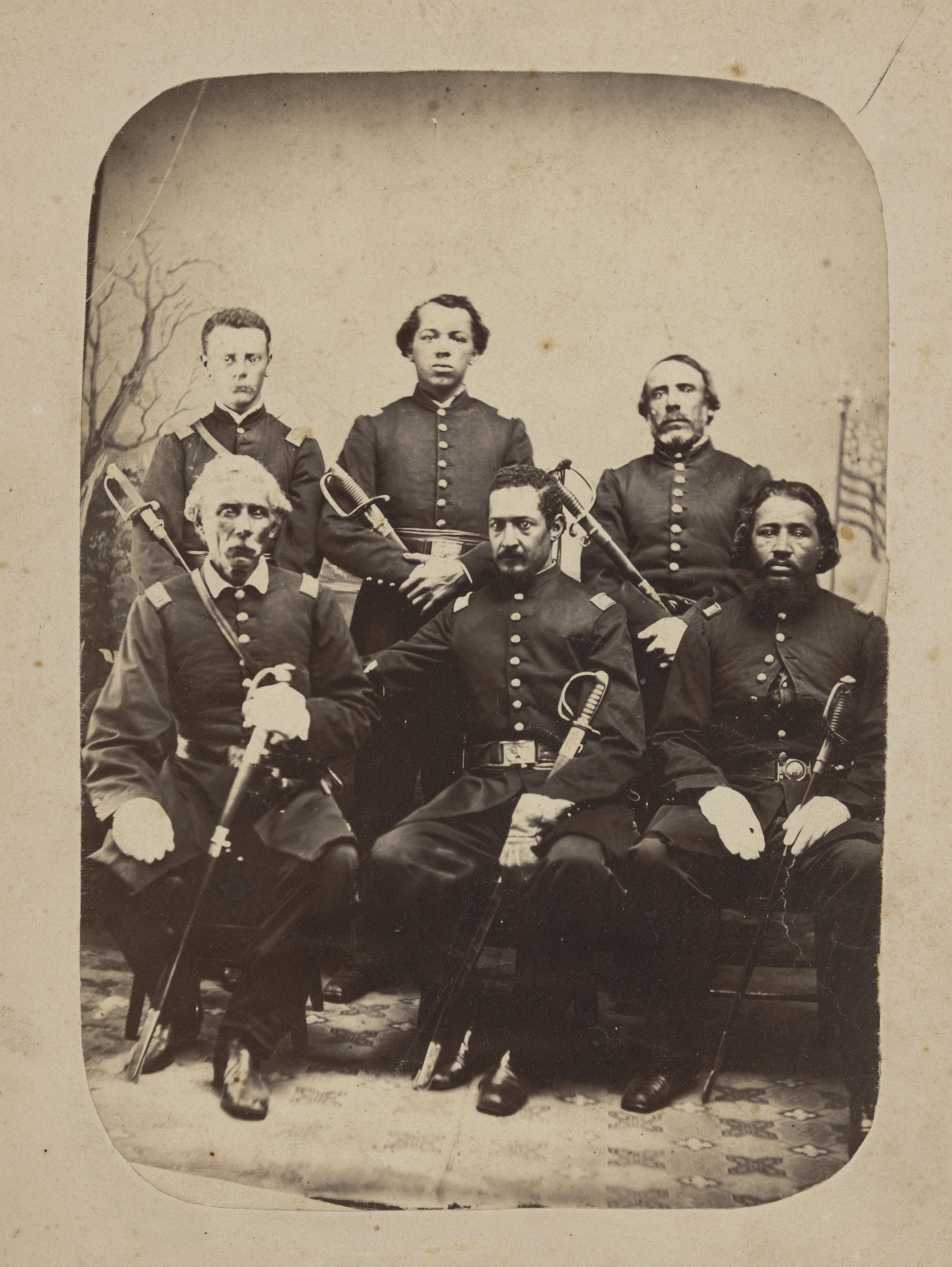 Six Union officers pose for a formal studio portrait in full dress uniform with their sabers.