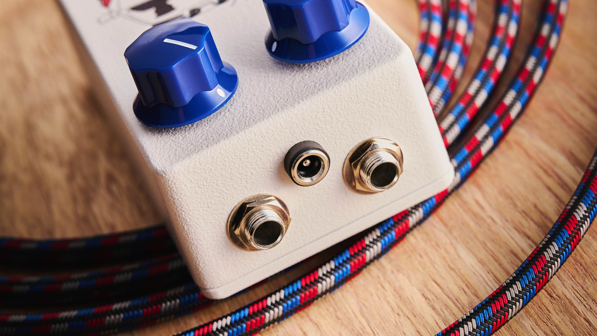 Funny Little Boxes Caught By The Fuzz: inspired by Supergrass, this two-knob fuzz has a white enclosure, blue dials, and a comic graphic of someone being apprehended in a police car.