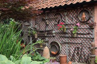 wall decorated with old tools and caribbean plants