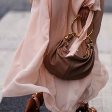 A guest at Paris fashion week crossing the road wearing a floaty Chloé dress, reminiscent of a lightweight perfume