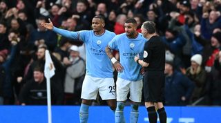Manchester City players Riyad Mahrez and Manuel Akanji protest with the assistant referee after Manchester United's equaliser in the derby at Old Trafford.