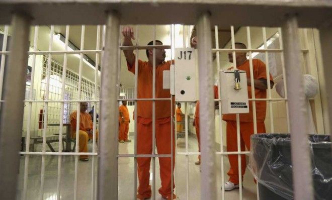 Immigration detainees stand behind bars at the Immigration and Customs Enforcement detention facility on Feb. 28, 2013 in Florence, Ariz. Most detainees typically remain in custody for severa