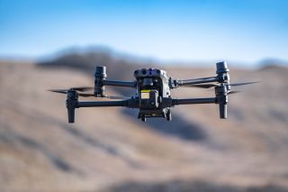 A military drone in flight observing positions