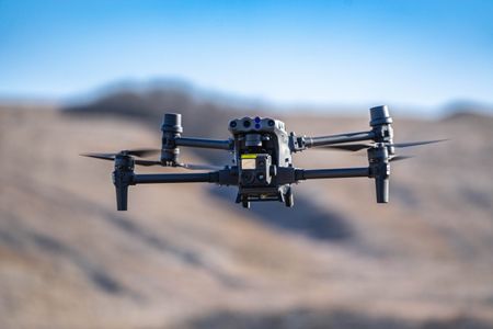 A military drone in flight observing positions