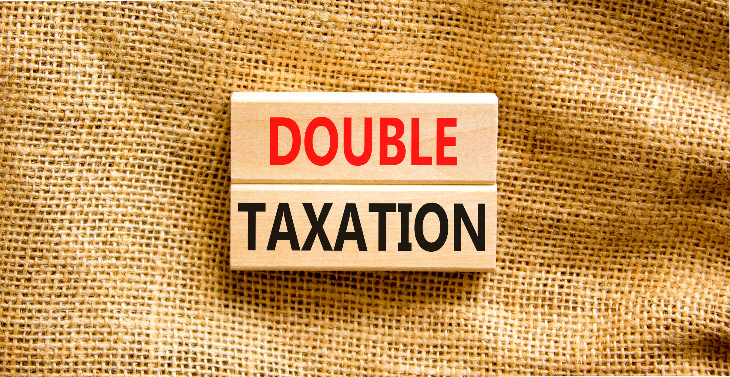 the words double taxation on stacked wooden blocks