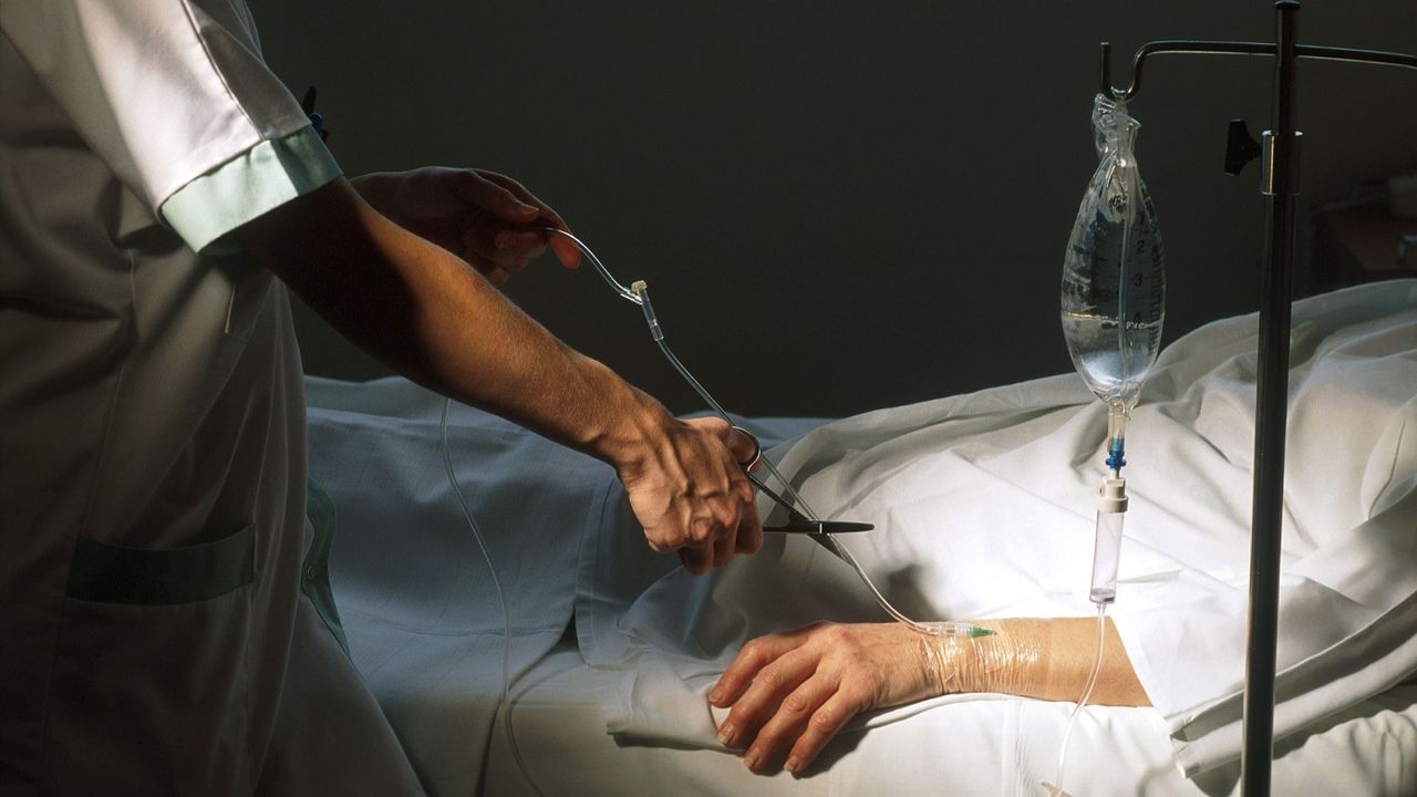 A medical professional snips a life support cord