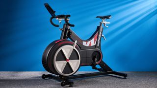 the wattbike air with a black and white front wheel, adjustable seat, and phone holder with app compatibility